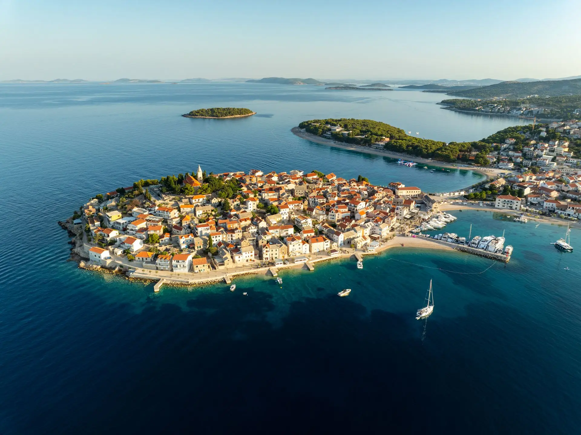 by på en lille holm med huse og omgivende hav og frodige grønne øer